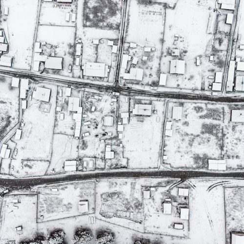 Aerial view of a snow-covered village in Altai Republic, Russia, showcasing winter architecture.
