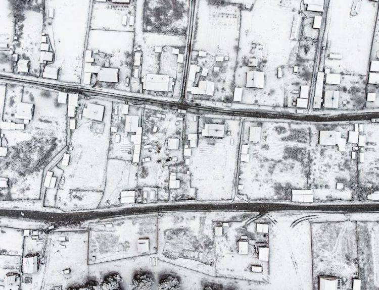 Aerial view of a snow-covered village in Altai Republic, Russia, showcasing winter architecture.