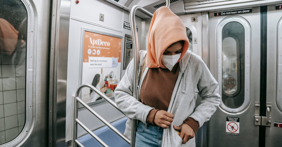 Muslim female in casual clothes medical mask and traditional headscarf in subway train