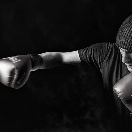 A powerful black and white image of a boxer throwing a punch, showcasing strength and focus.