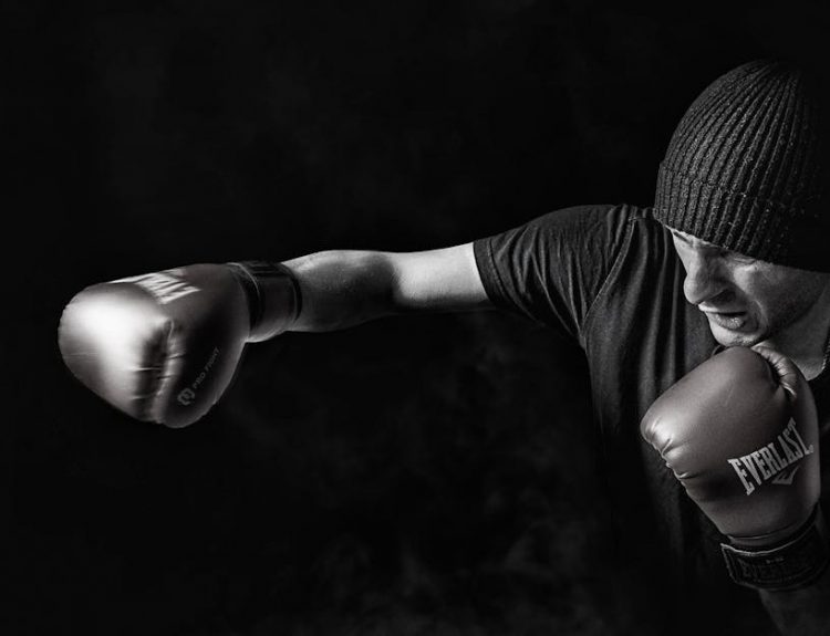 A powerful black and white image of a boxer throwing a punch, showcasing strength and focus.
