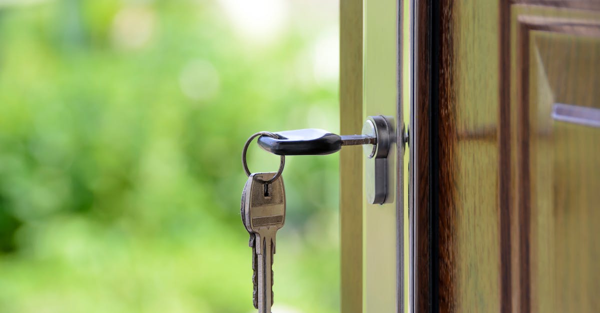 Key inserted in door lock against a blurred green background, symbolizing security and real estate.