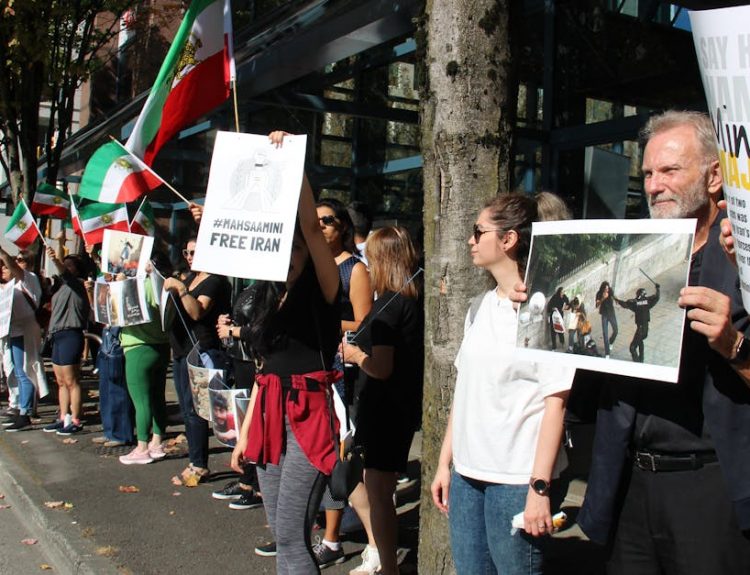A peaceful protest in Vancouver advocating for Iranian rights with flags and placards.