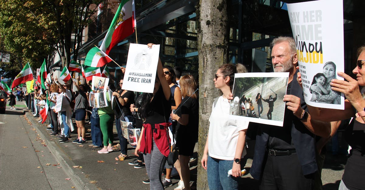 A peaceful protest in Vancouver advocating for Iranian rights with flags and placards.