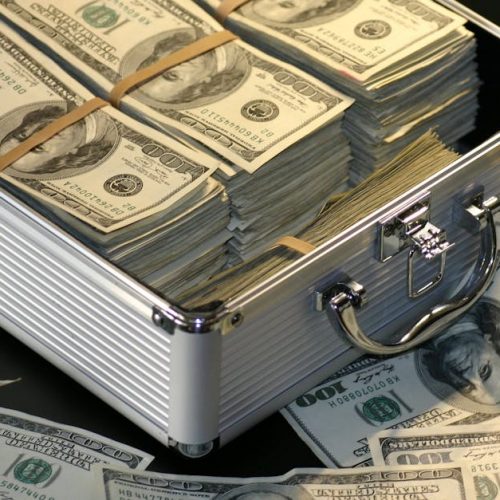A metallic briefcase full of US dollar bills, symbolizing wealth and investment.