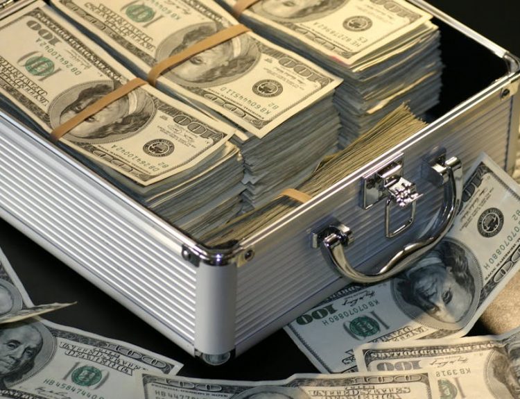 A metallic briefcase full of US dollar bills, symbolizing wealth and investment.