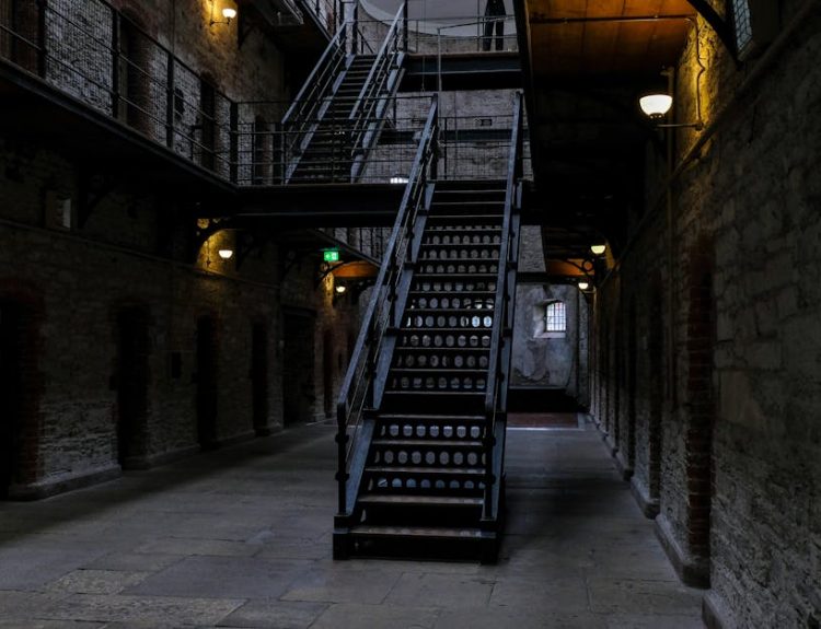 Explore a dimly lit corridor with a historic staircase, atmospheric and intriguing.