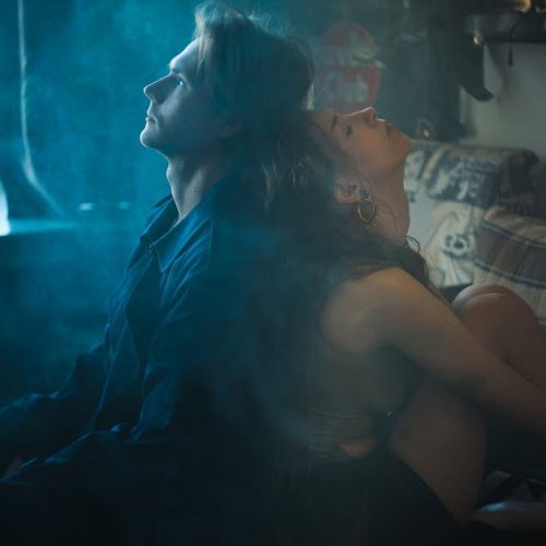Dramatic and intimate moment captured with a couple in a smoky, intimate bedroom setting.