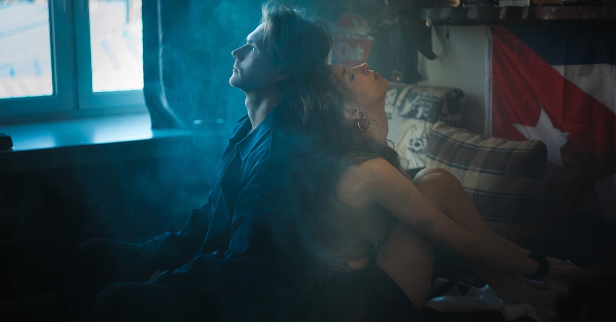 Dramatic and intimate moment captured with a couple in a smoky, intimate bedroom setting.