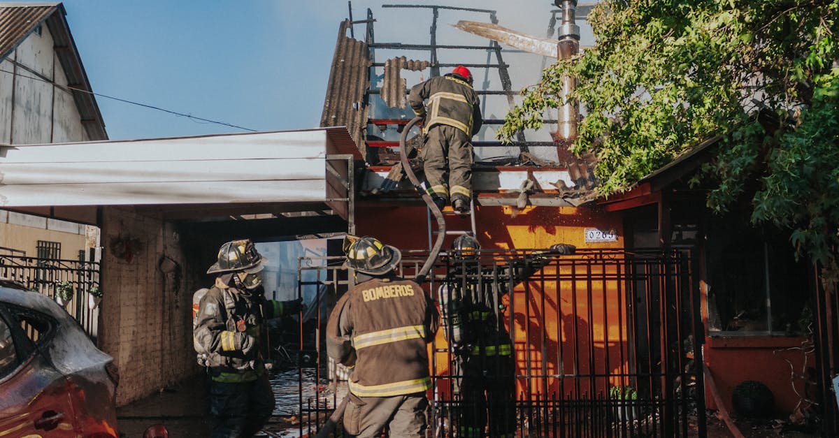 Firefighters working to extinguish a house fire, showcasing bravery and teamwork outdoors.
