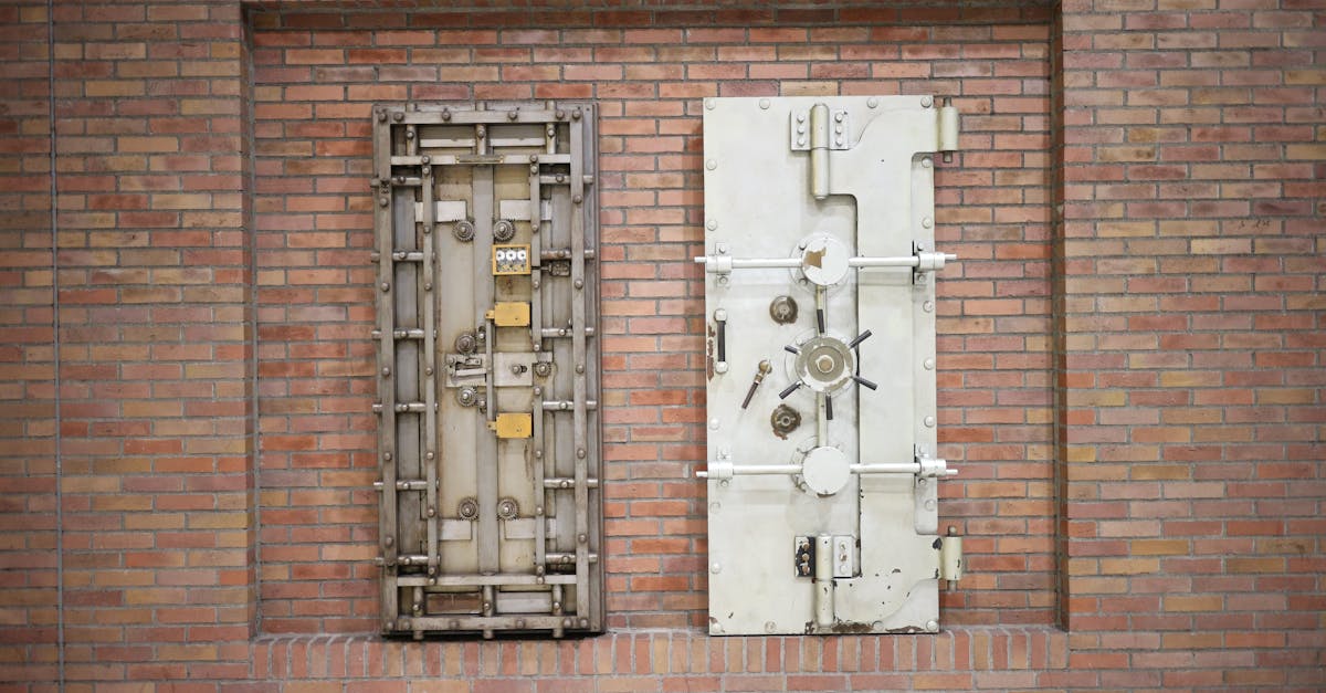 Two steel security vault doors attached to a vintage brick wall, showcasing industrial strength.
