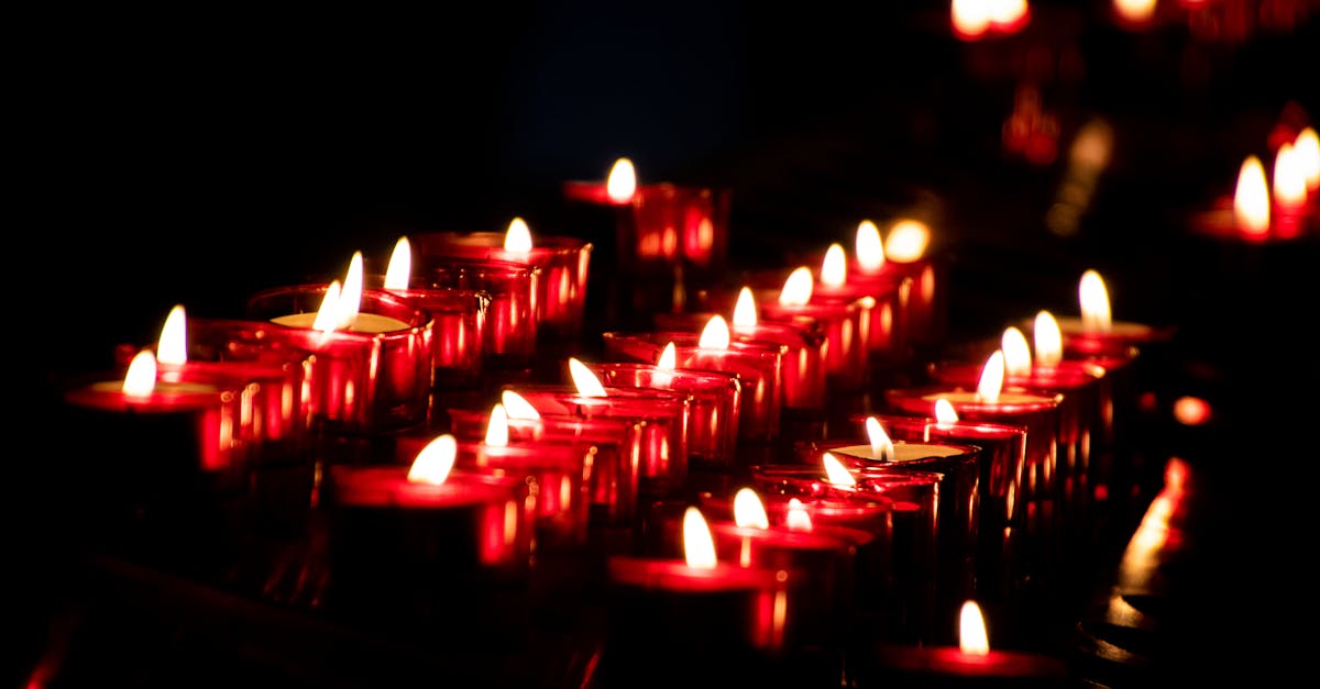 Rows of glowing red candles create a warm, peaceful ambience in the darkness.