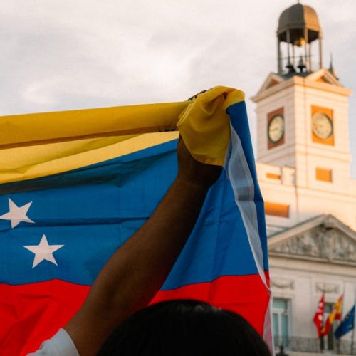 Venezuelan flag waving during a protest at Puerta del Sol, Madrid.