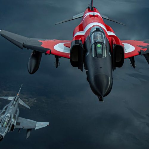 Three jet fighters soar through the sky in a dramatic aerial formation, showcasing their power.
