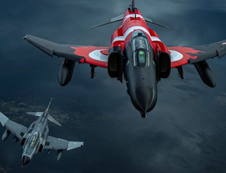 Three jet fighters soar through the sky in a dramatic aerial formation, showcasing their power.