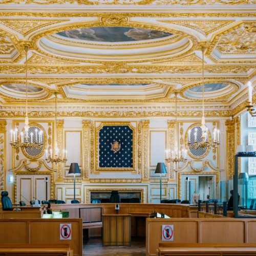 An ornate courtroom with golden details and chandeliers in Rennes, France.