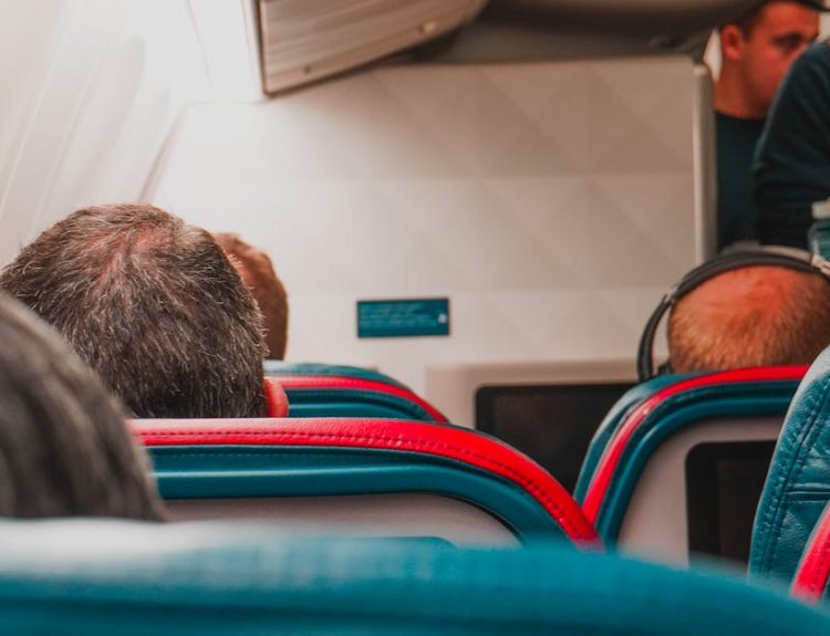Interior view of an airplane cabin with passengers seated, focusing on seats and layout.