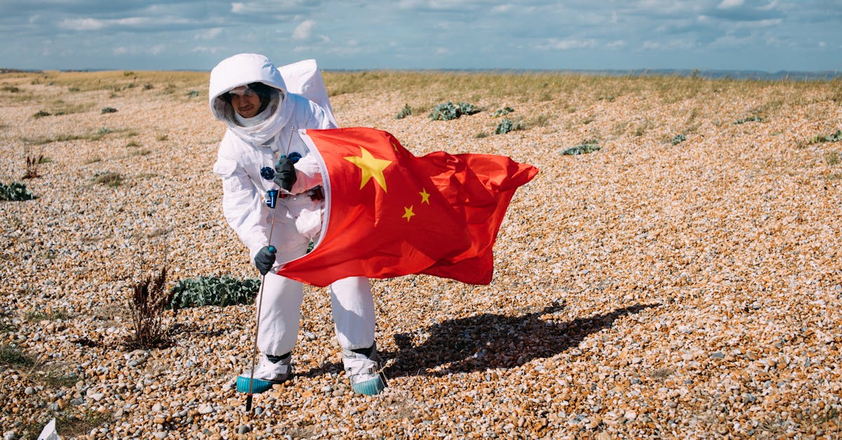 Person in a space suit holding a Chinese flag in a rocky desert setting, portraying an astronaut scene.
