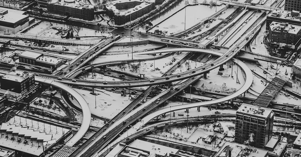 Stunning aerial view of a city highway interchange covered in snow, captured in black and white.