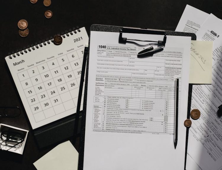 A neatly organized workspace featuring tax forms, calendar, magnifying glass, and office supplies for efficient tax preparation.