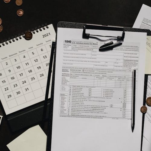 A neatly organized workspace featuring tax forms, calendar, magnifying glass, and office supplies for efficient tax preparation.