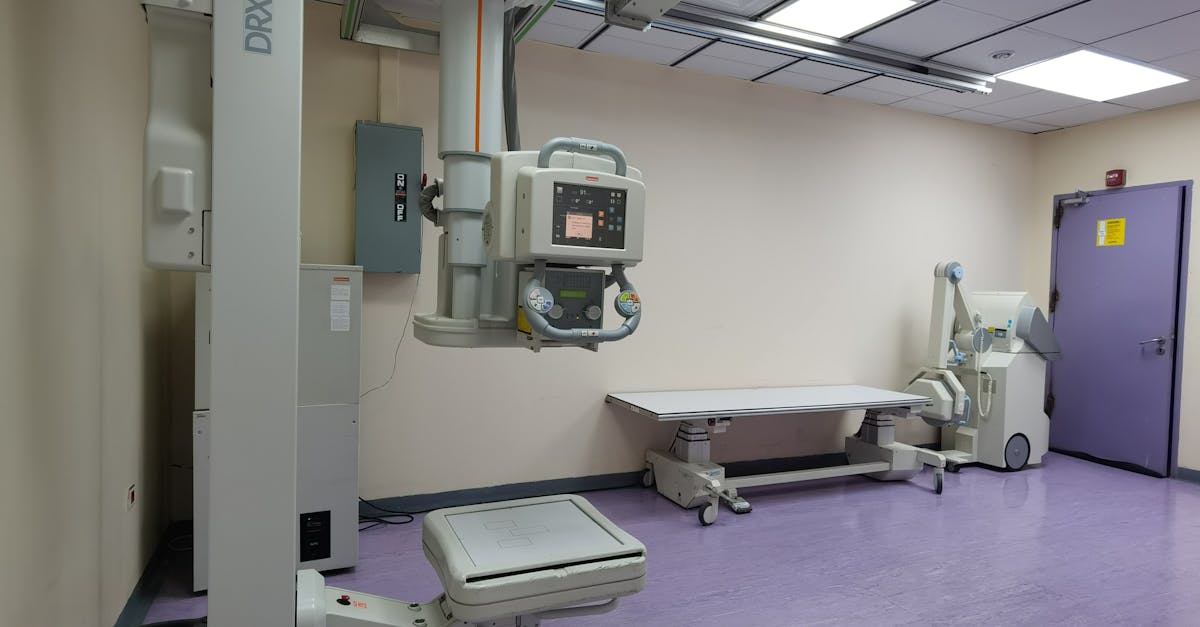 Interior view of a well-equipped hospital X-ray room with medical imaging devices.