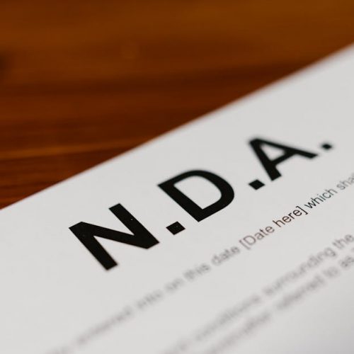 Focused close-up of an NDA document on a wooden desk, highlighting contract details.
