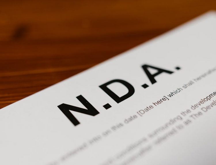 Focused close-up of an NDA document on a wooden desk, highlighting contract details.