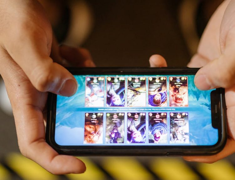 Close-up of hands playing a mobile game on a smartphone, showcasing the game's interface.