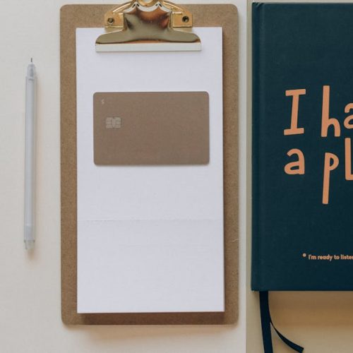 A minimalist office setup featuring a planner, clipboard, card, and pen, perfect for planning and organization.