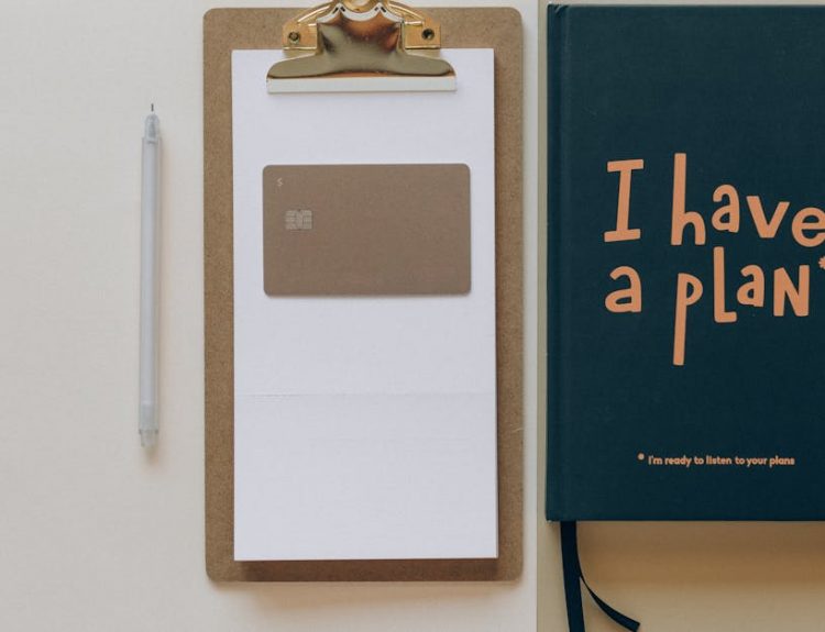 A minimalist office setup featuring a planner, clipboard, card, and pen, perfect for planning and organization.
