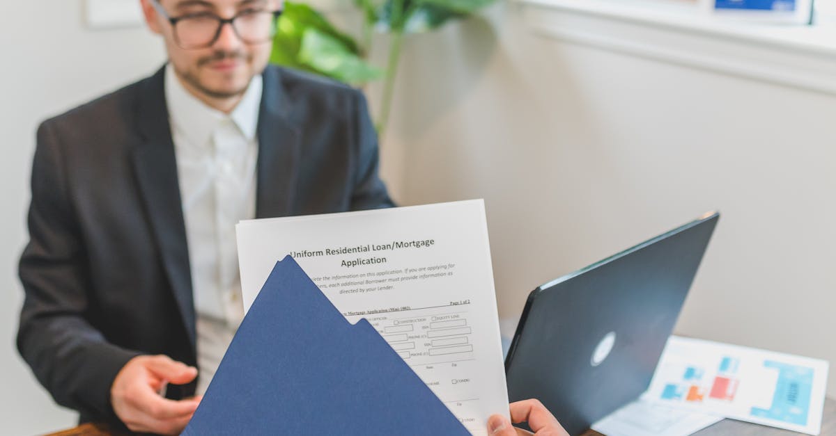 Mortgage broker and client discussing loan application with documents on table.