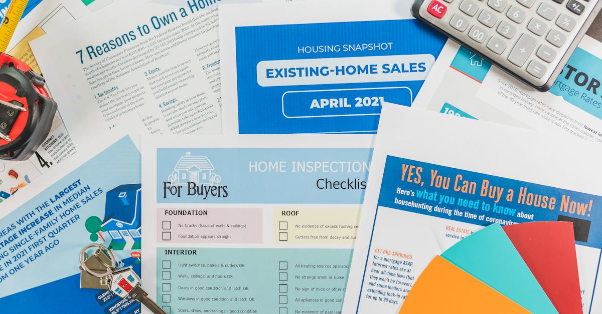 Flat lay of real estate brochures, checklists, and a calculator for home buying.