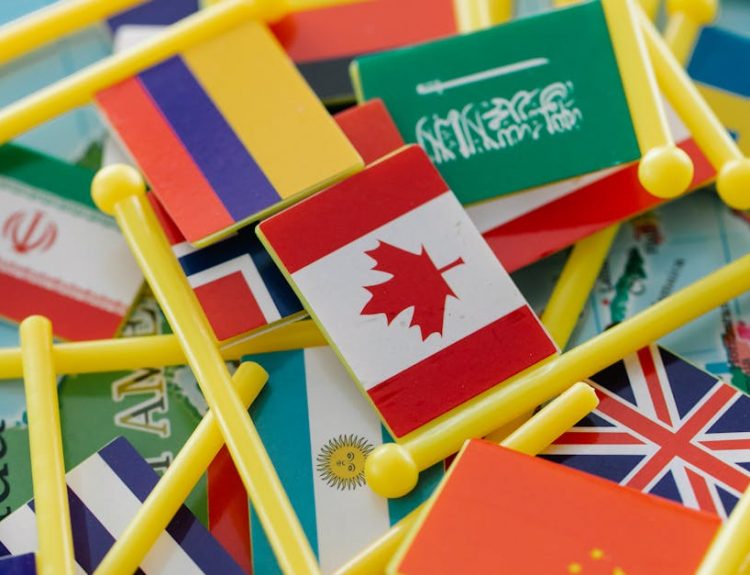 Colorful mini flags of countries on a world map, symbolizing global connections.