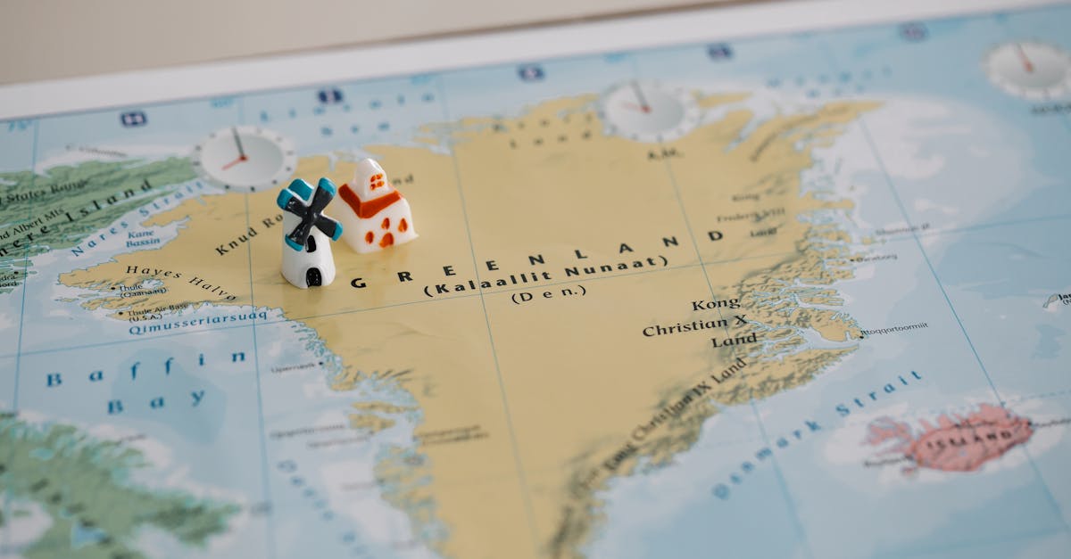 Toy houses on a detailed map of Greenland, highlighting geographic features. Ideal for travel concepts.