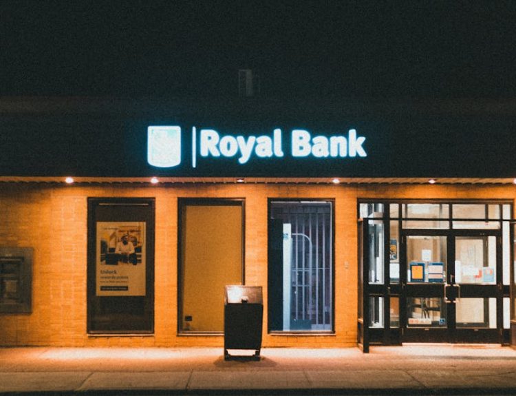 Exterior view of a Royal Bank building at night with glowing facade lights.
