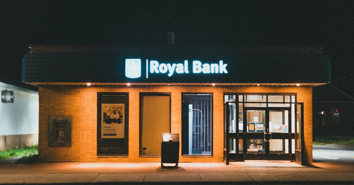 Exterior view of a Royal Bank building at night with glowing facade lights.