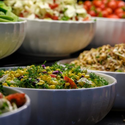 A colorful assortment of fresh salads and vegetables in ceramic bowls. Perfect for healthy food photography.
