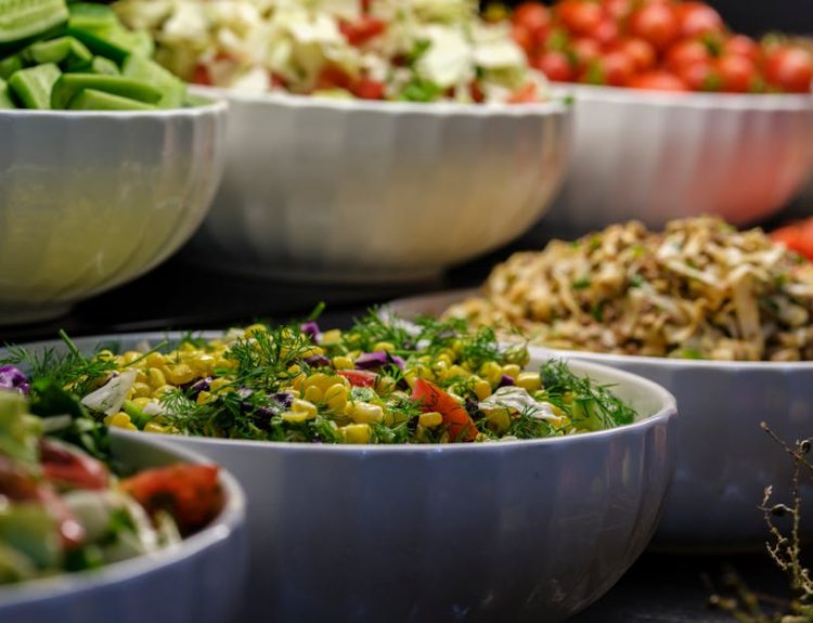 A colorful assortment of fresh salads and vegetables in ceramic bowls. Perfect for healthy food photography.