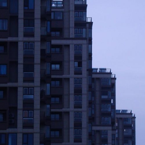 A contemporary skyscraper in a cityscape at dusk showcasing modern architectural design.