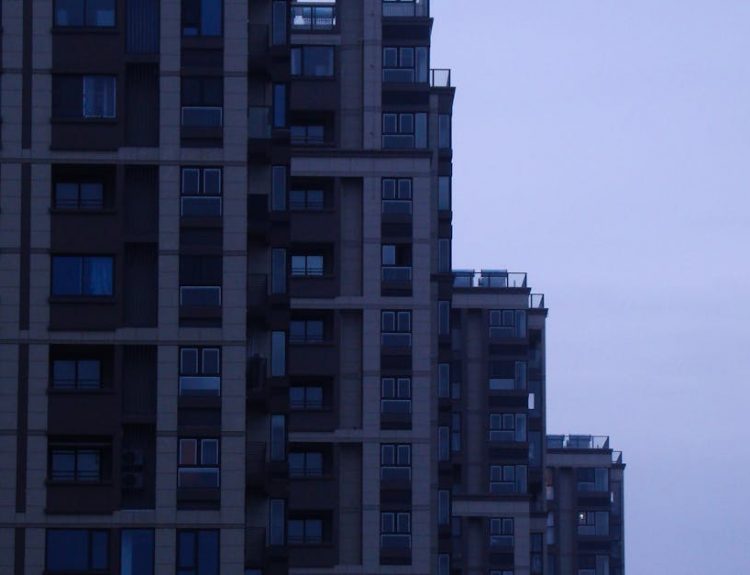 A contemporary skyscraper in a cityscape at dusk showcasing modern architectural design.