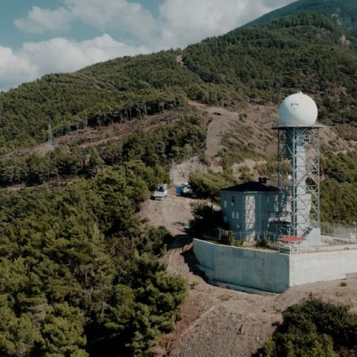 Weather station nestled in the lush mountains of Hatay, Türkiye, under a clear sky.