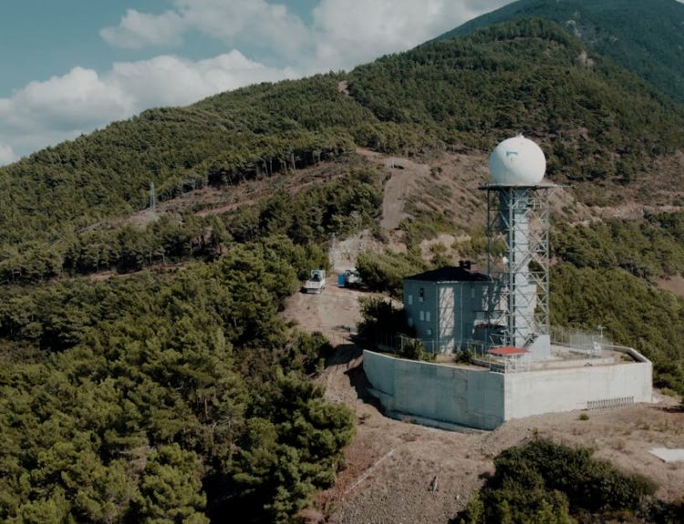 Weather station nestled in the lush mountains of Hatay, Türkiye, under a clear sky.