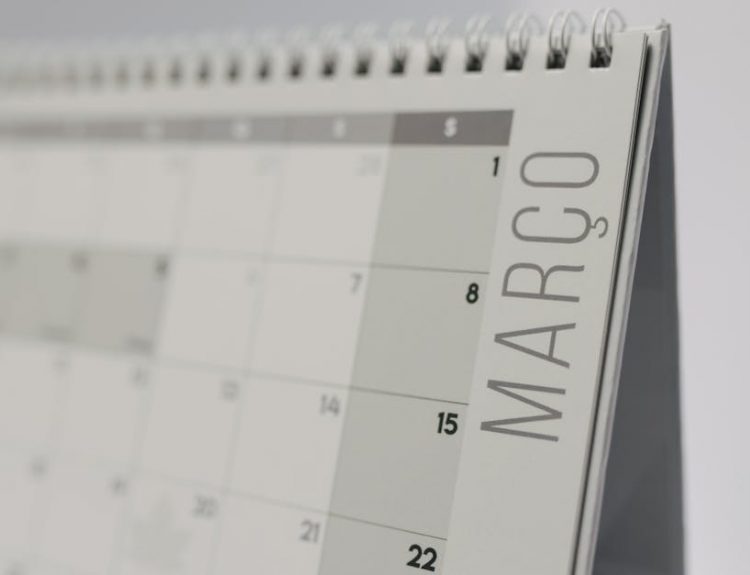 Close-up of a spiral-bound desk calendar showing March in a minimalist style.