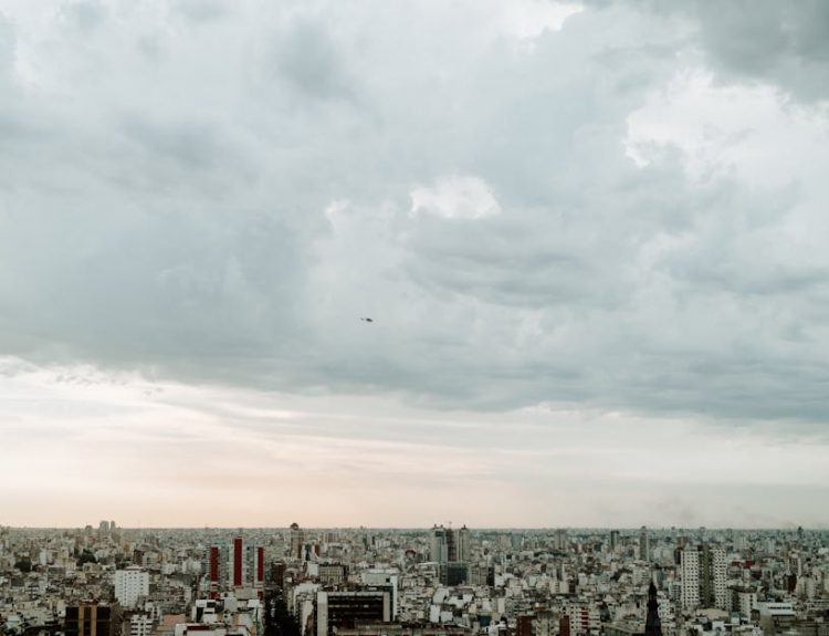 A panoramic aerial view of Buenos Aires skyline under a cloudy sky, emphasizing urban density.