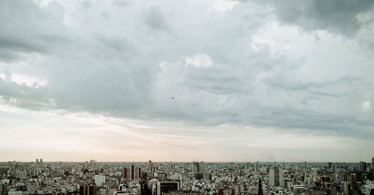A panoramic aerial view of Buenos Aires skyline under a cloudy sky, emphasizing urban density.