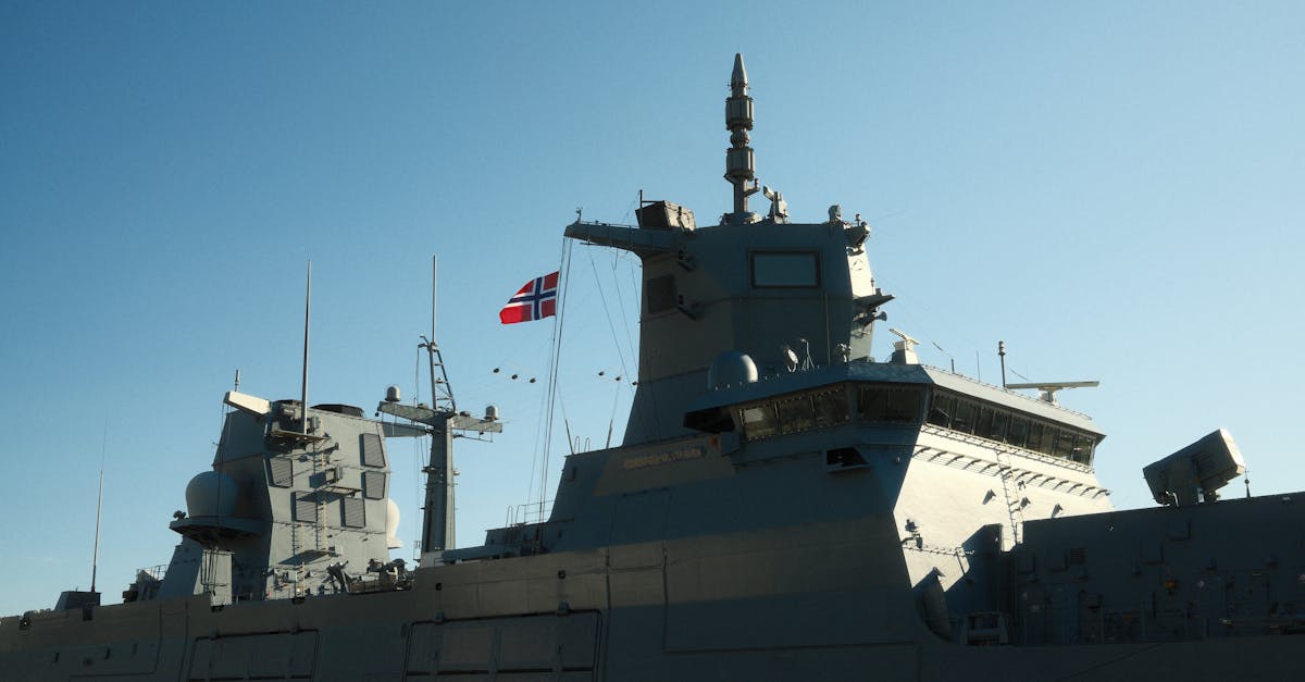 A Norwegian navy frigate with a national flag in daylight.