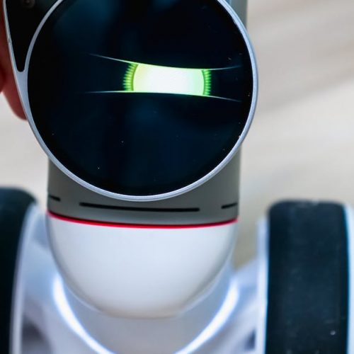 Detailed view of a wheeled robot being touched, showcasing tactile interaction.