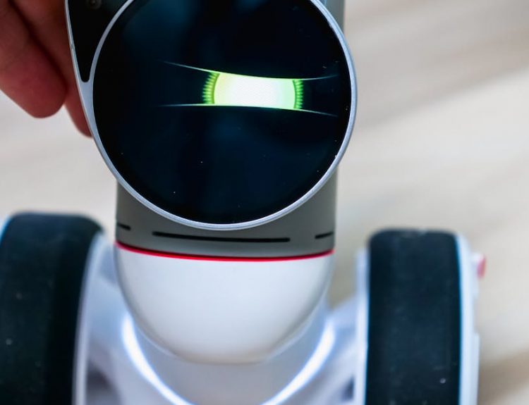 Detailed view of a wheeled robot being touched, showcasing tactile interaction.