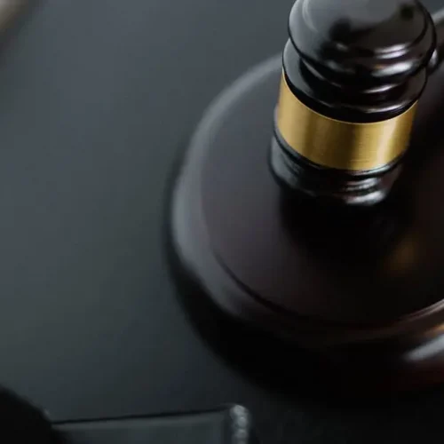 Close-up of a wooden judge's gavel on a black desk, symbolizing justice and law.